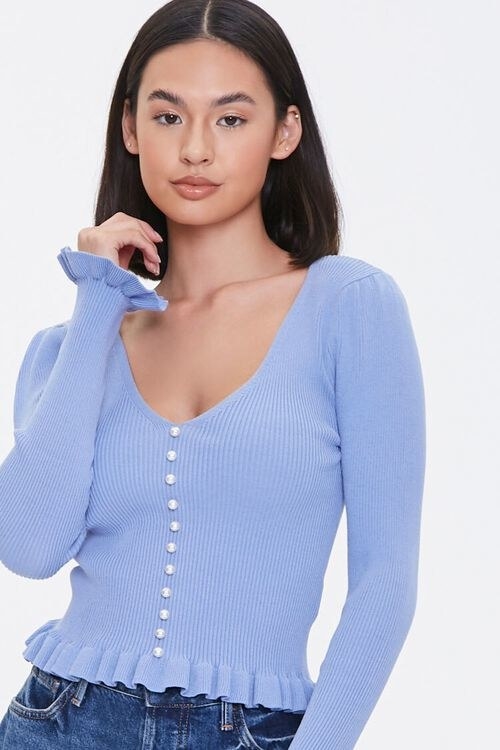 model in faux pearl sweater-knit top