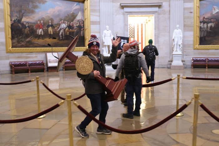 Rioter walking with a stolen podium inside the Capitol
