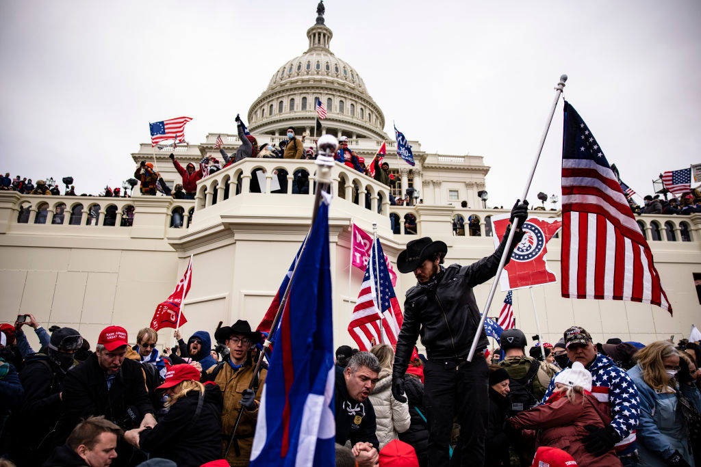 Rioters on the steps of the Capitol waving U.S. flags