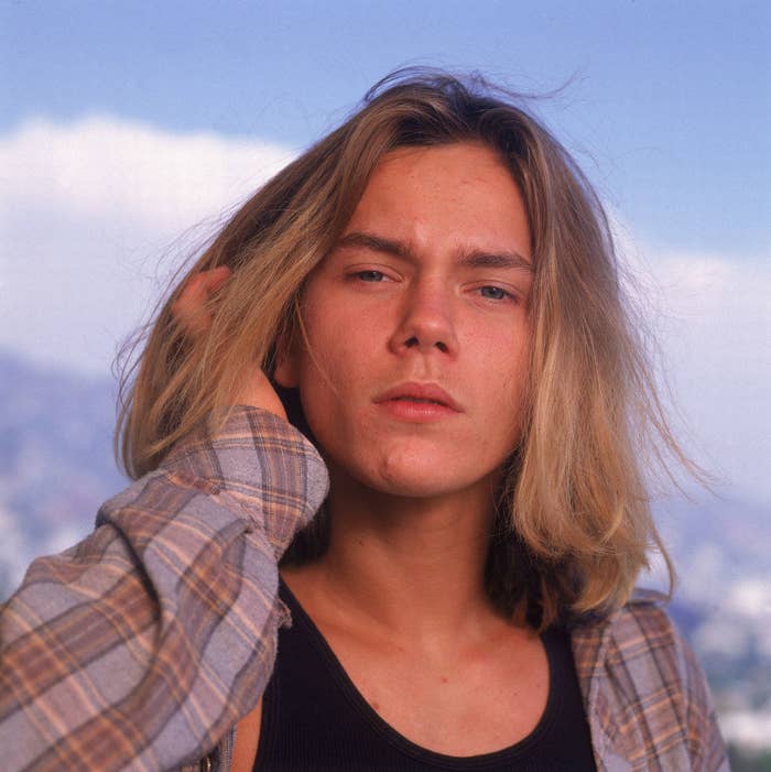 River Phoenix with long hair and wearing a flannel. It was the &#x27;90s after all.