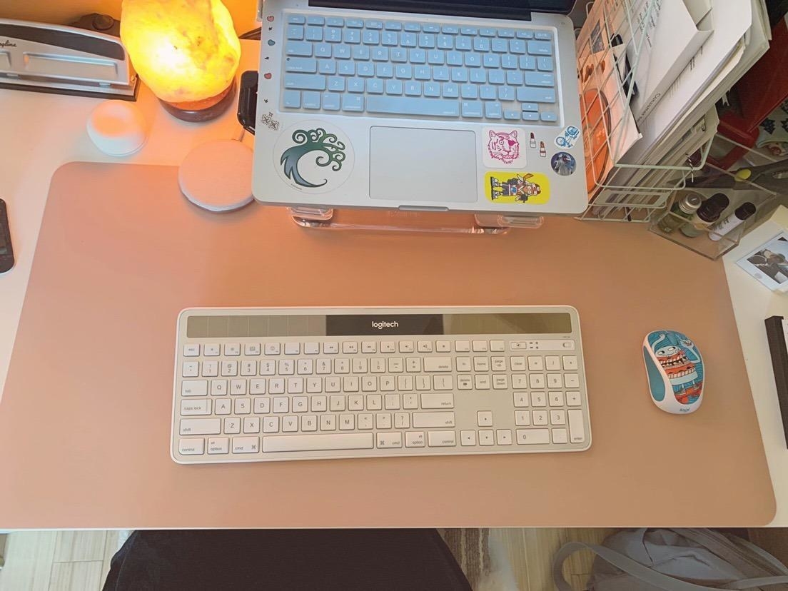 reviewer&#x27;s pink desk pad with their keyboard and mouse on it 