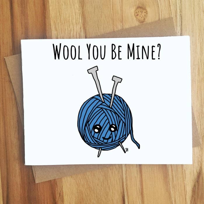A drawing of a blue ball of wool, with &quot;Wool you be mine?&quot; written in black type across the top