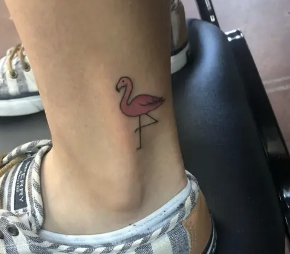 A tattoo of a tiny pink flamingo