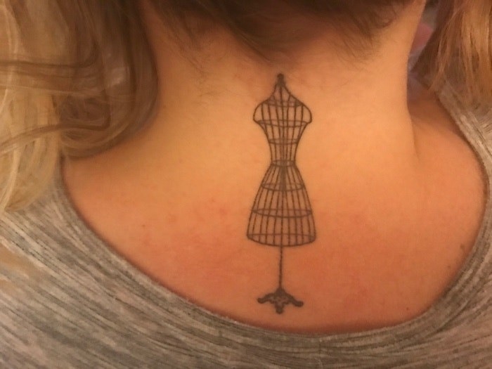 A behind-the-neck tattoo of a costumer&#x27;s old mannequin