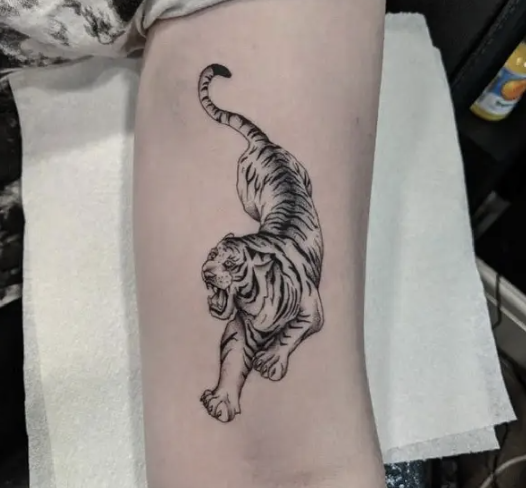 An arm tattoo of a black-and-white tiger