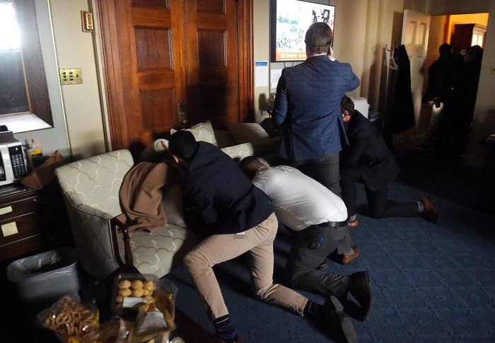 Congress members and staff hiding behind a barricaded door