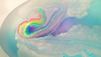a rainbow from the bath bomb in a tub of water