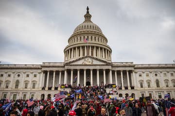 A  large group of pro-Trump protesters stand on the East steps of the Capitol Building after storming its grounds on January 6, 2021 in Washington, DC. A pro-Trump mob stormed the Capitol, breaking windows and clashing with police officers