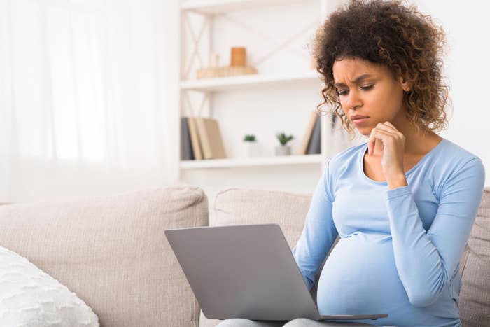 A pregnant woman is on the computer