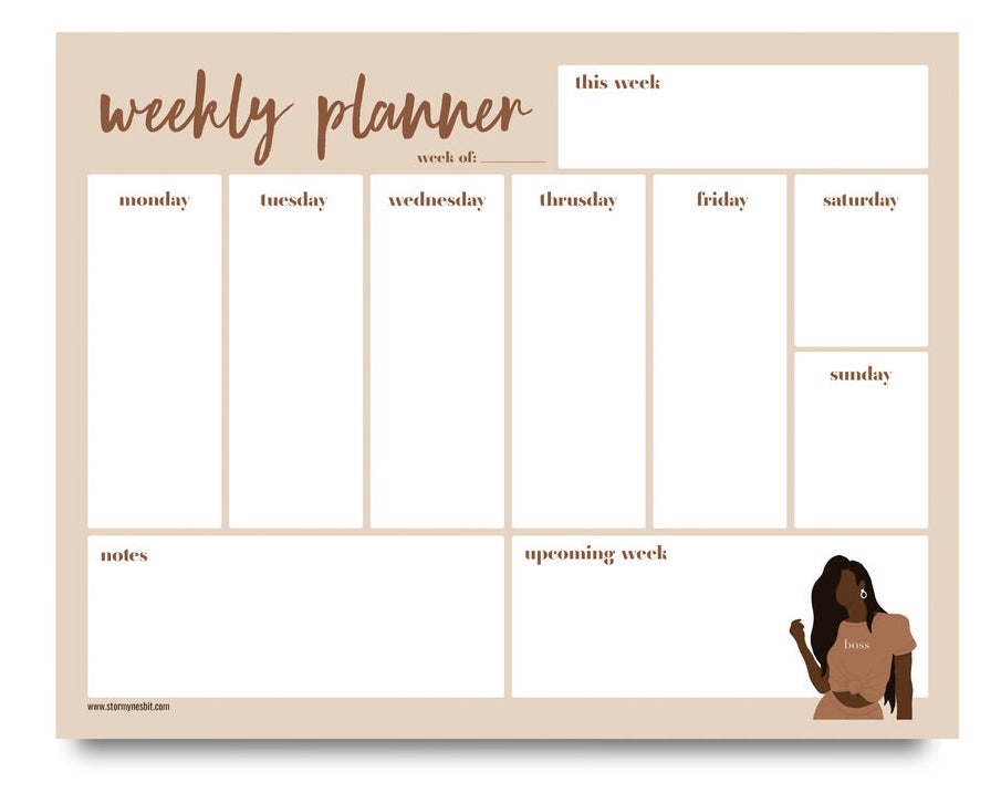 A desk pad that says &quot;weekly planner&quot; with boxes to write in for each day of the week and an illustration in the bottom right corner of a Black woman wearing a shirt that says &quot;boss&quot; 