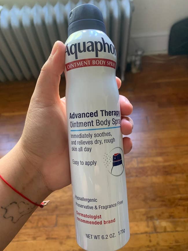 Reviewer holding can of body spray