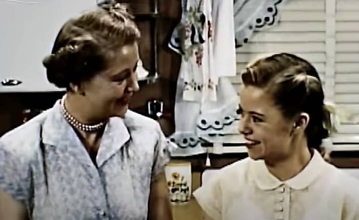 A young women smiling at her mother, dressed in 1950s clothing