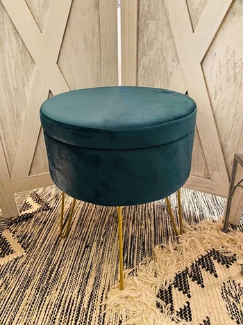 A reviewer's photo of the teal ottoman/table which has gold hairpin legs