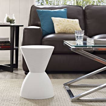 The white accent stool which is hourglass shaped