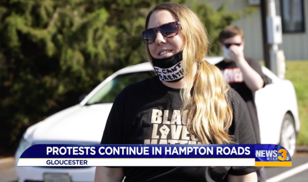 A woman appears on a news program wearing a &quot;Black Lives Matter&quot; T-shirt and &quot;I can&#x27;t breathe&quot; face mask