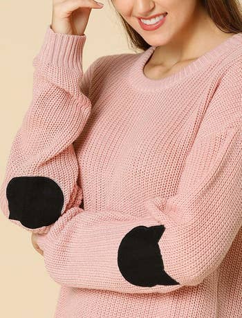 A model wearing the sweater in pink