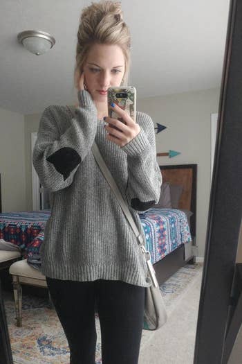 A reviewer in the gray pullover sweater with black cat face shaped elbow patches
