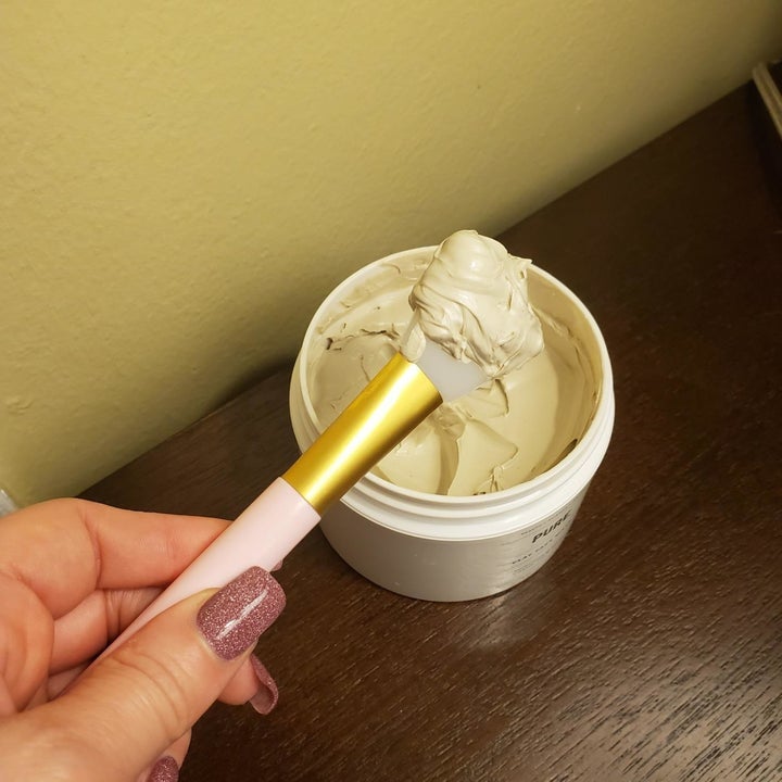 reviewer photo showing their face mask brush being used to scoop a face mask out of its jar