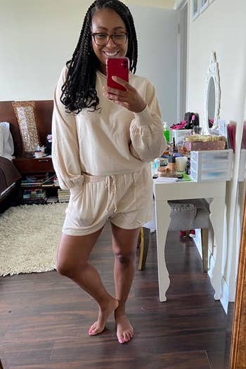 A reviewer wearing the long-sleeved crop top and shorts set in cream