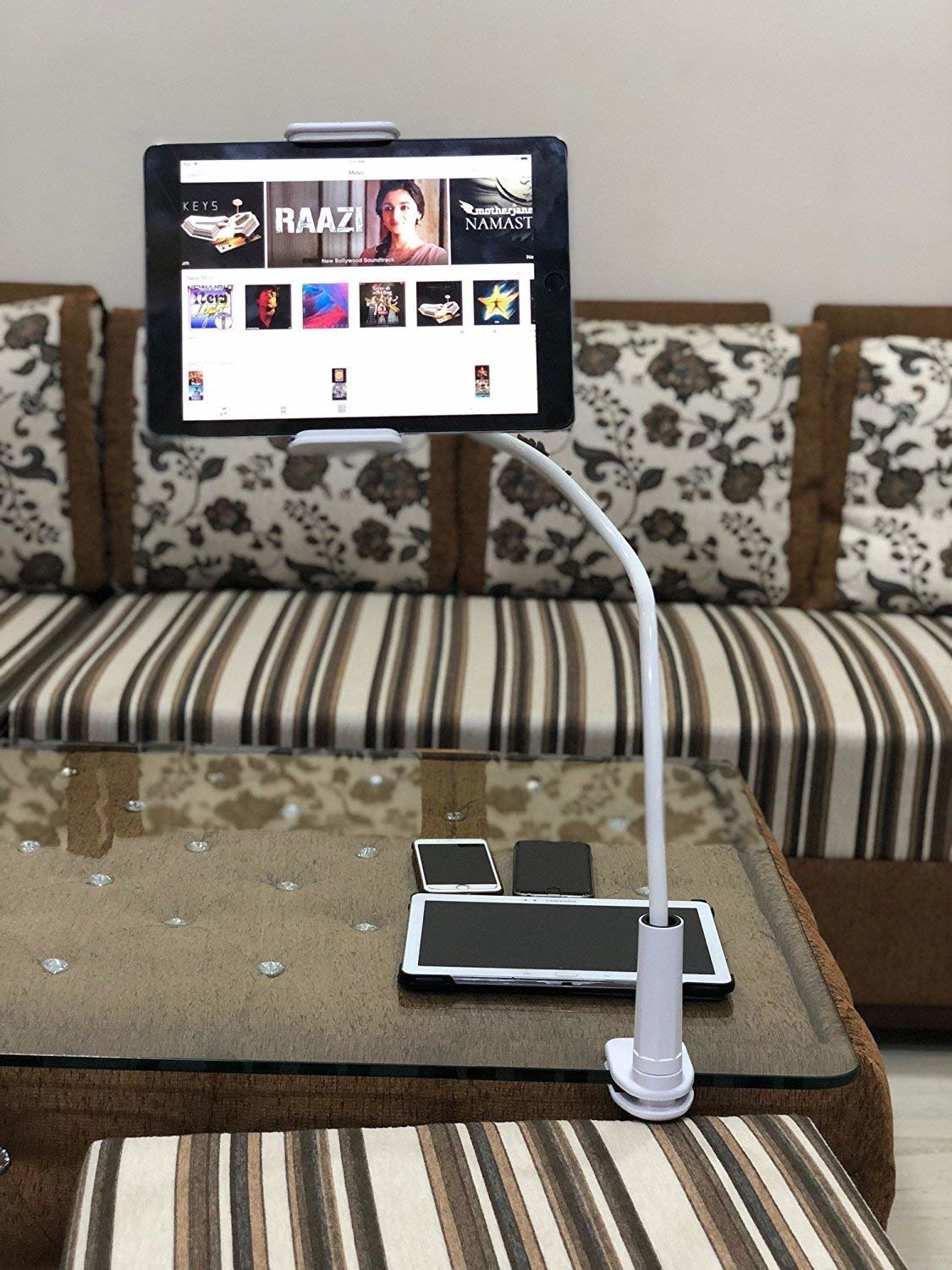 A tablet clipped to the end of a table on the phone holder