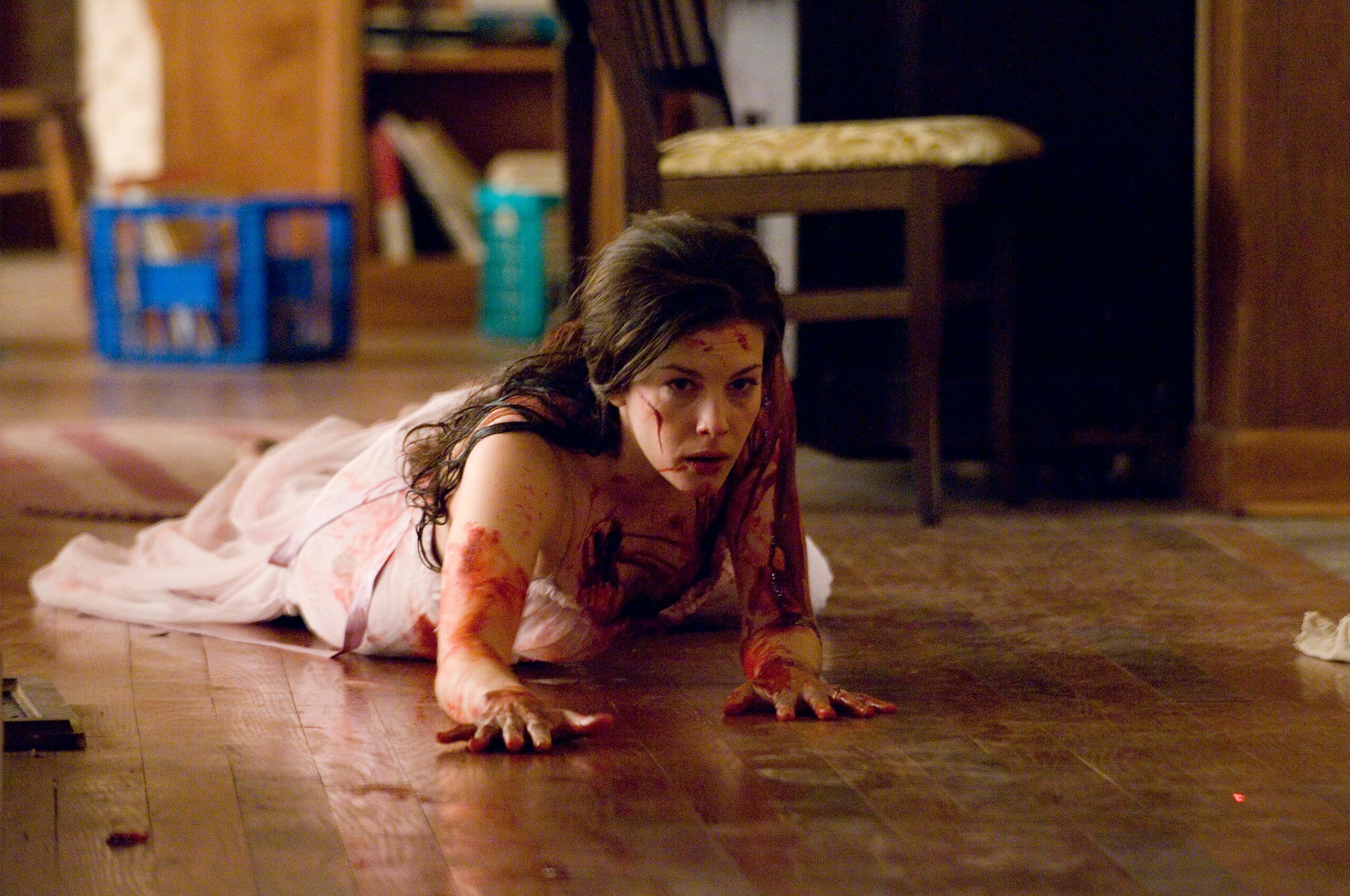 Liv Tyler in the Strangers bloody and in distress on the floor as she tries to escape a trio of murders