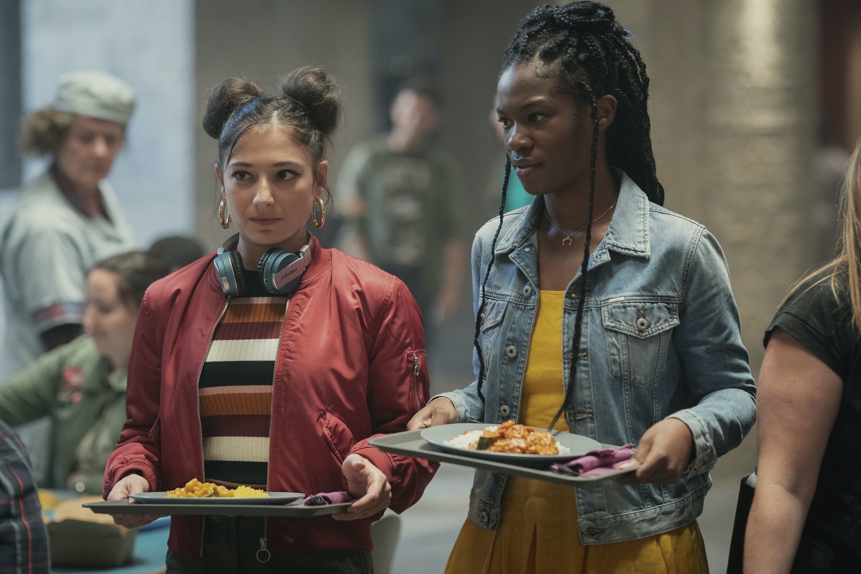 Musa and Aisha standing in line at the cafeteria in Fate: The Winx Saga 