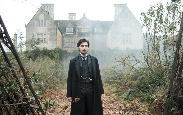 Daniel Radcliffe in victorian attire in front of a haunted manor that&#x27;s shrouded in fog and mystery 