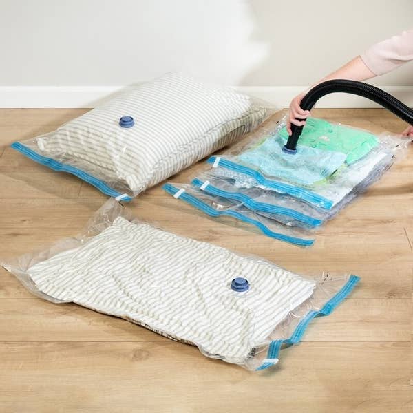 Model vacuums the air out of a clear storage bag with blue seal