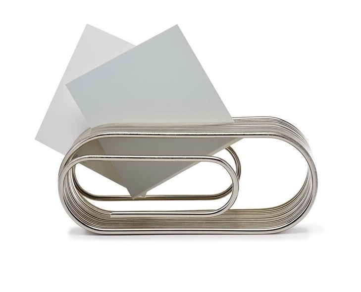 Stainless steel paper clip organizer holds pieces of white paper