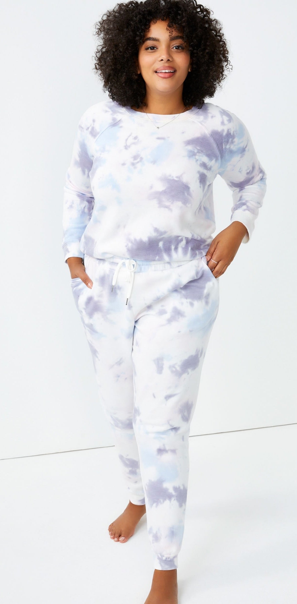 Model wears white, purple, and blue tie-dye joggers with matching sweatshirt