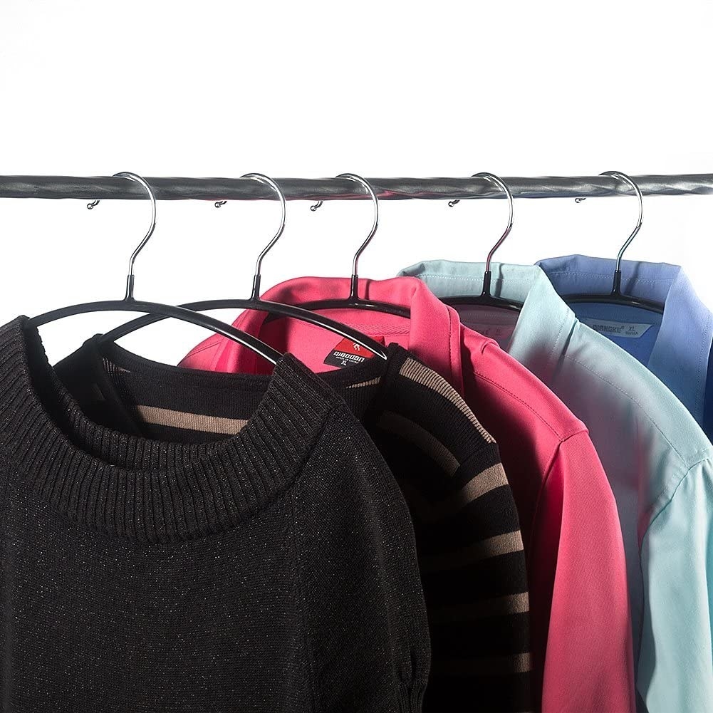 Several shirts and sweaters hung on the hangers