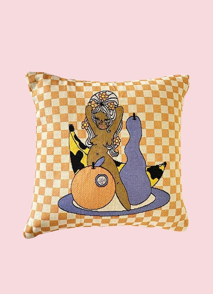 a Valfre character in the nude posing with various fruits on an orange and white checkered pillow 