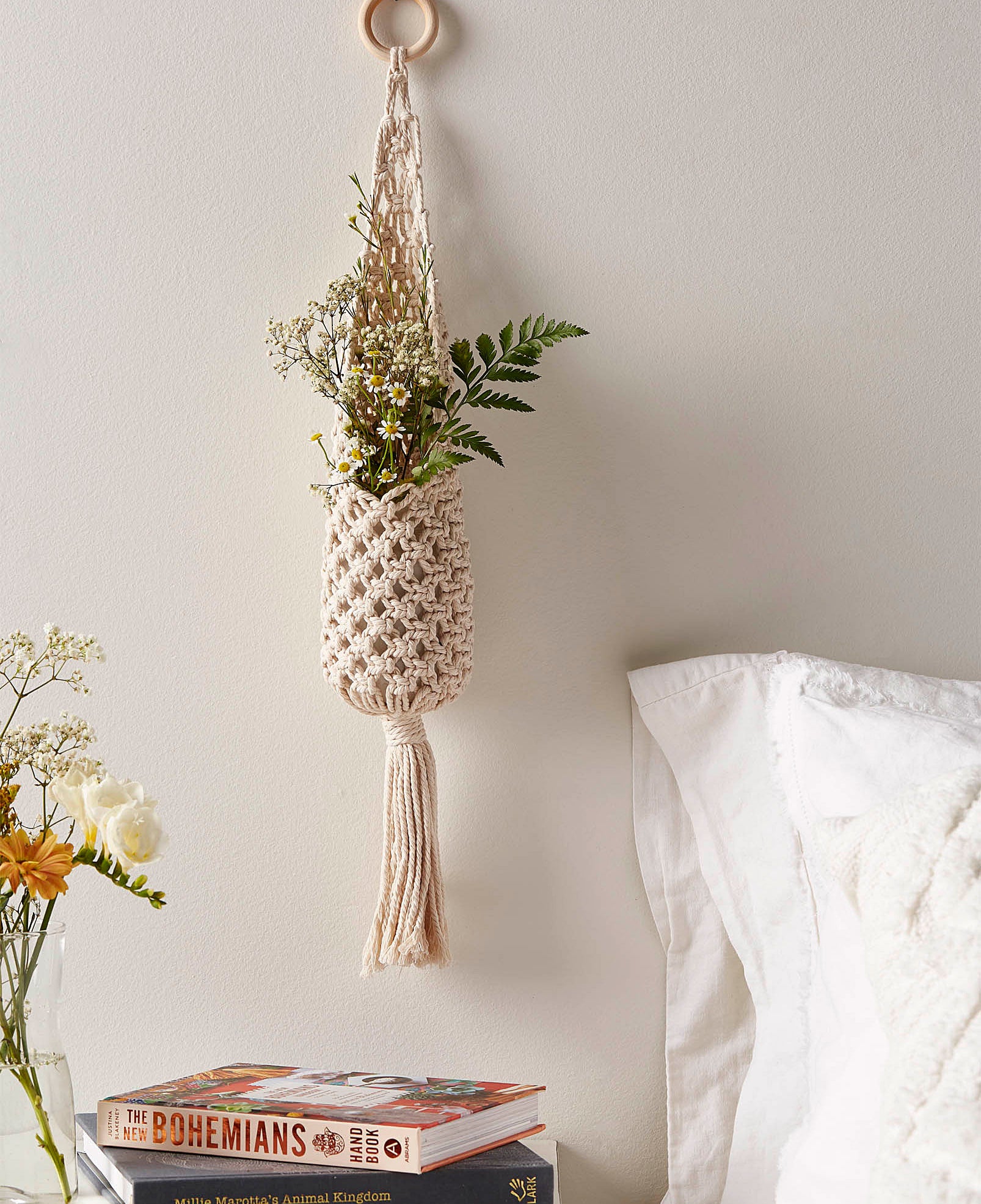 A macrame plant pouch hanging on a wall 