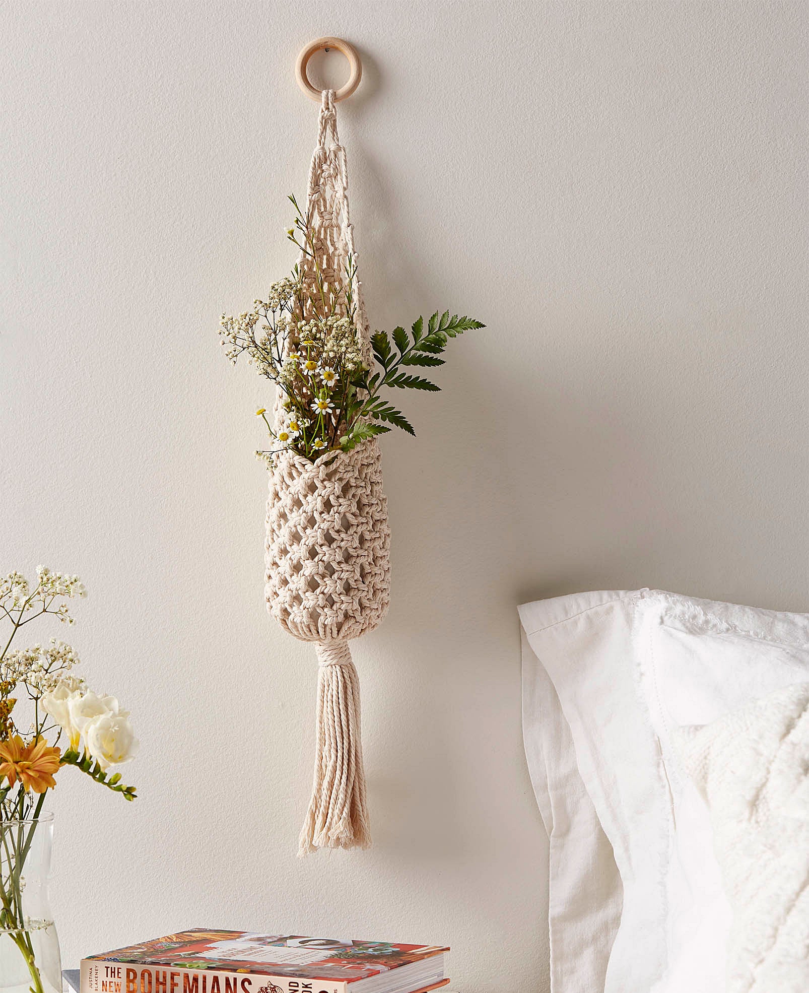 A macrame plant pouch hanging on a wall 