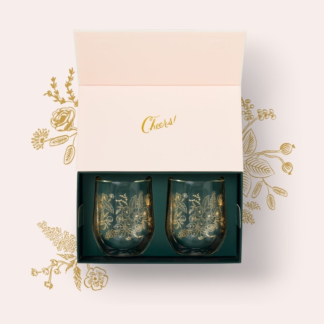 The clear stemless wine glasses with gold metallic gold floral pattern on them