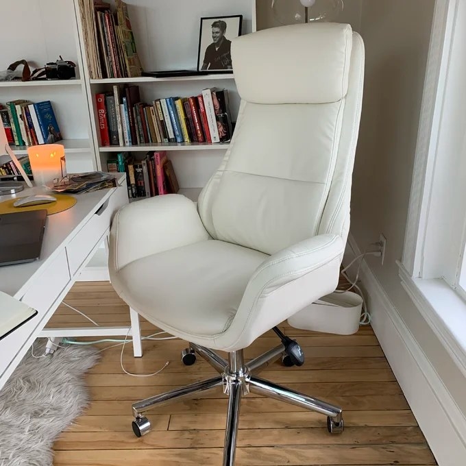 A close up of the chair in front of a white desk