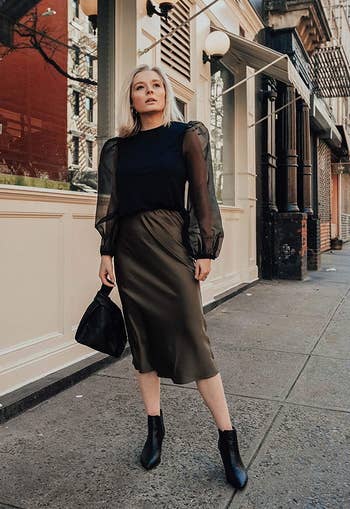 A model wearing the skirt in dark olive