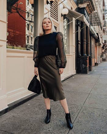 A model wearing the skirt in dark olive