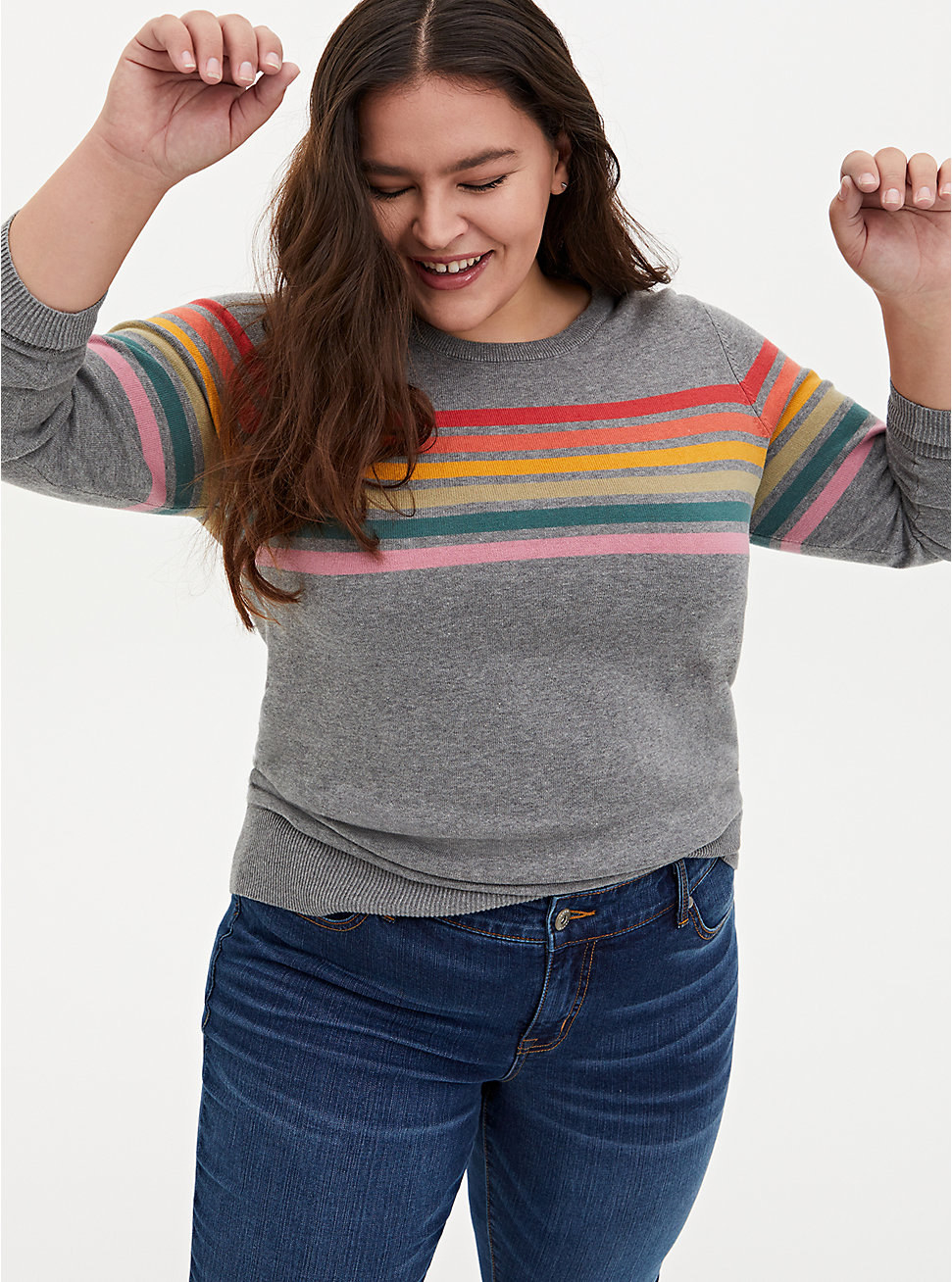a model in a gray sweater with rainbow horizontal stripes