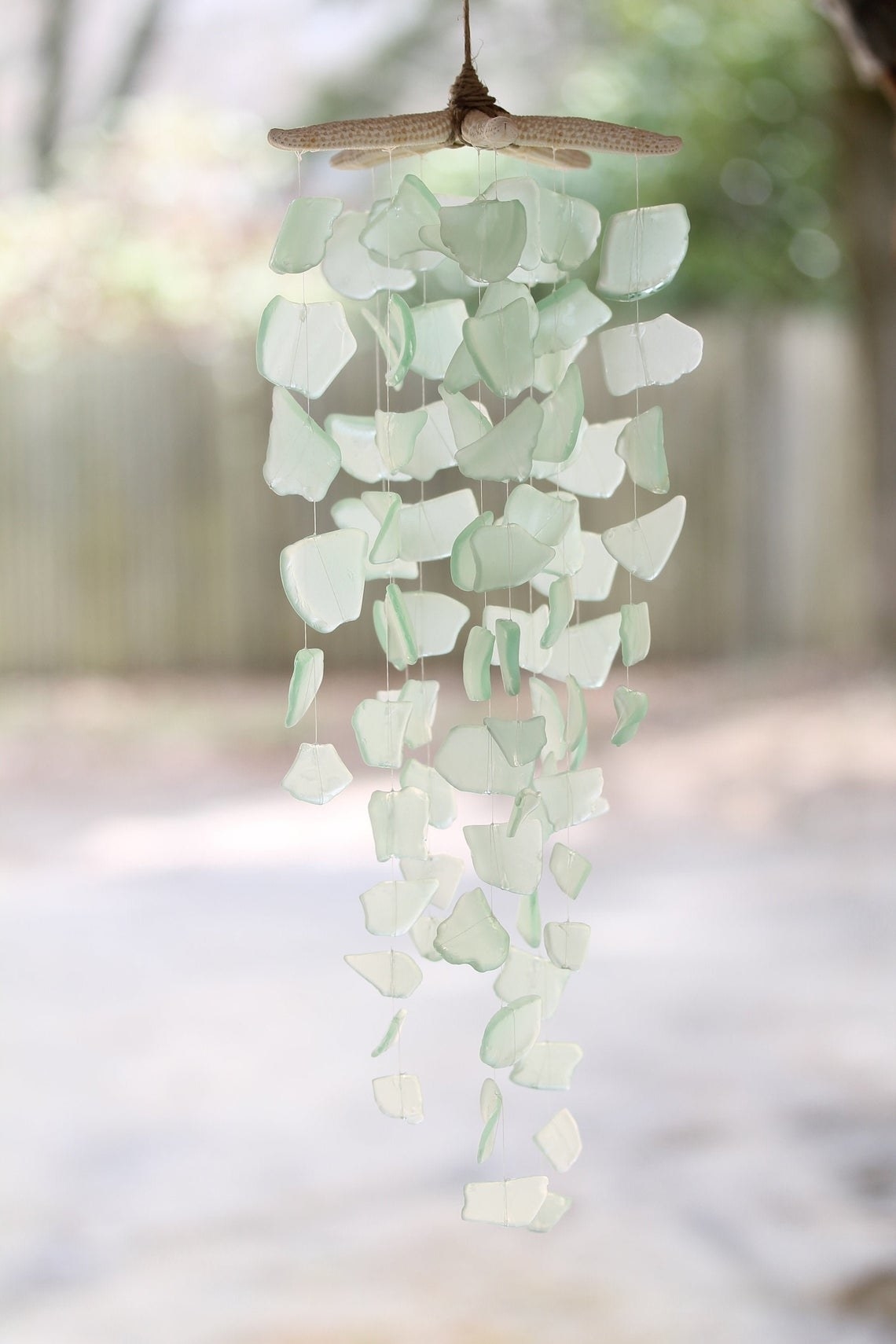 Soft green sea glass shards hung from a starfish into a chime 