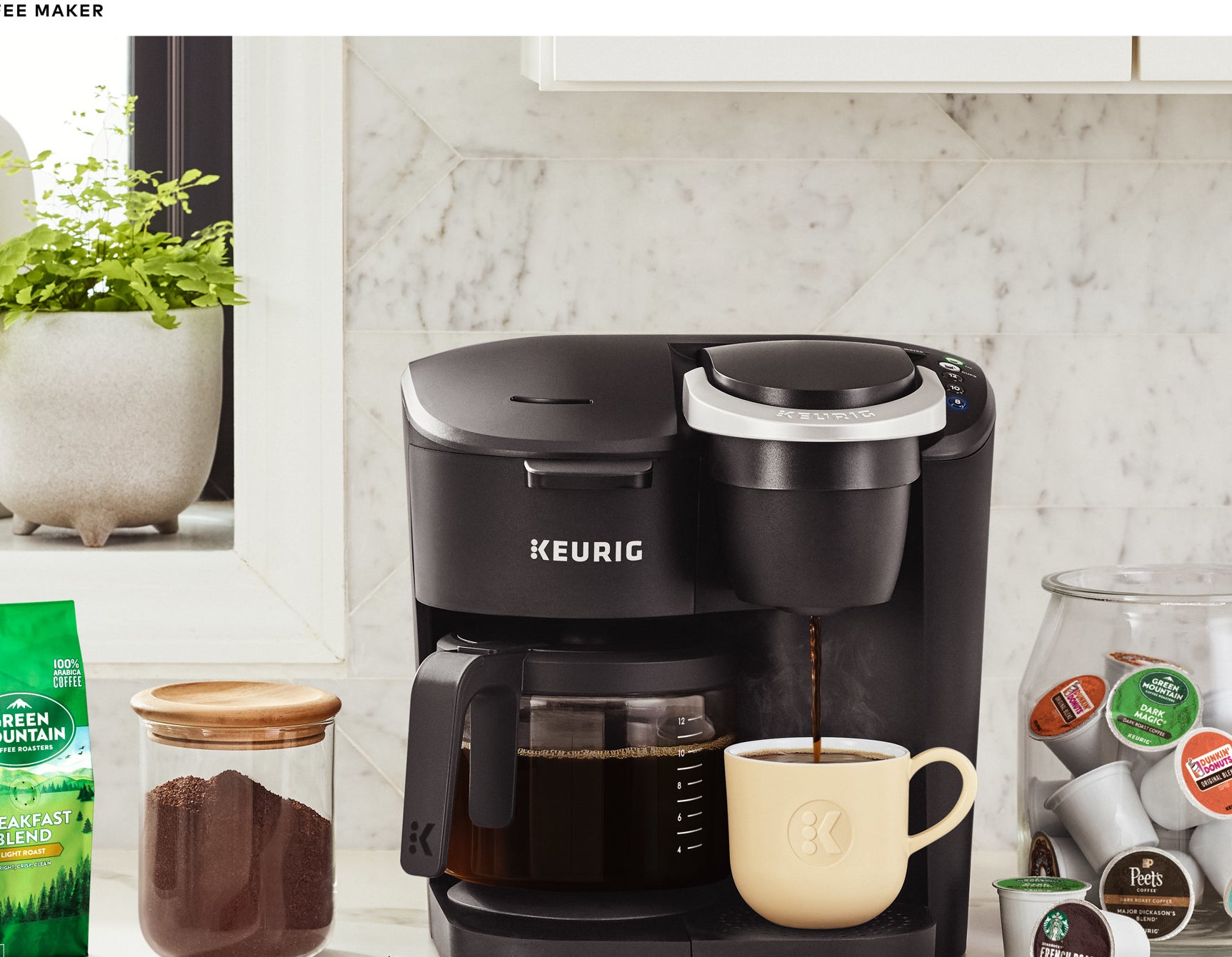 black keurig coffee machine with a pot on one side and a mug on the other