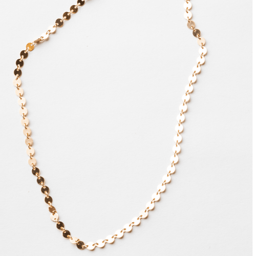 a gold necklace with small circles