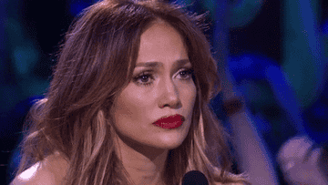 Jennifer Lopez looks wide-eyed and sadly at a contestant on American Idol