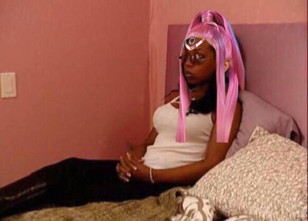 Tiffany New York Pollard sitting in bed wearing a Gaga wig and headpiece