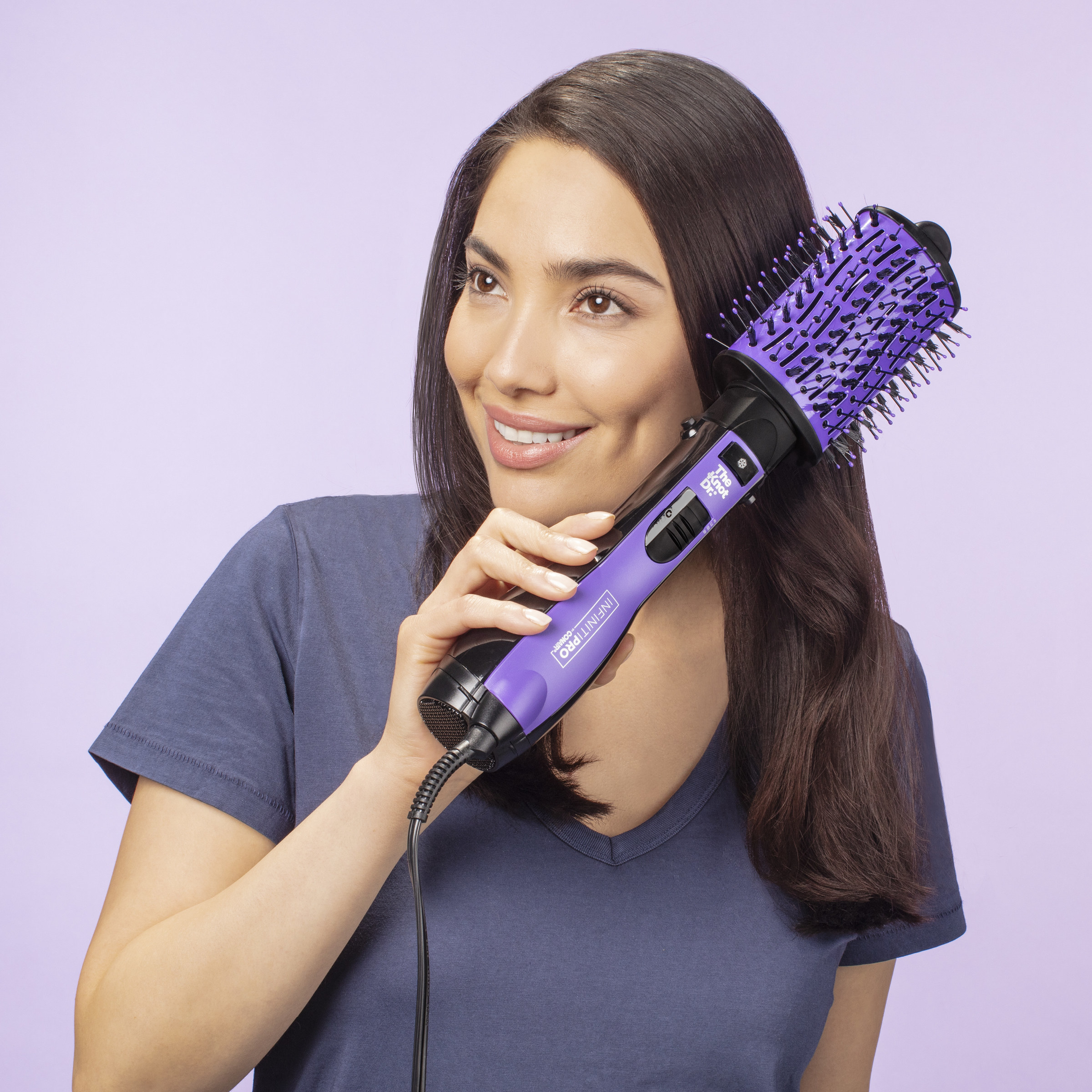 person using a purple hot air brush to style hair