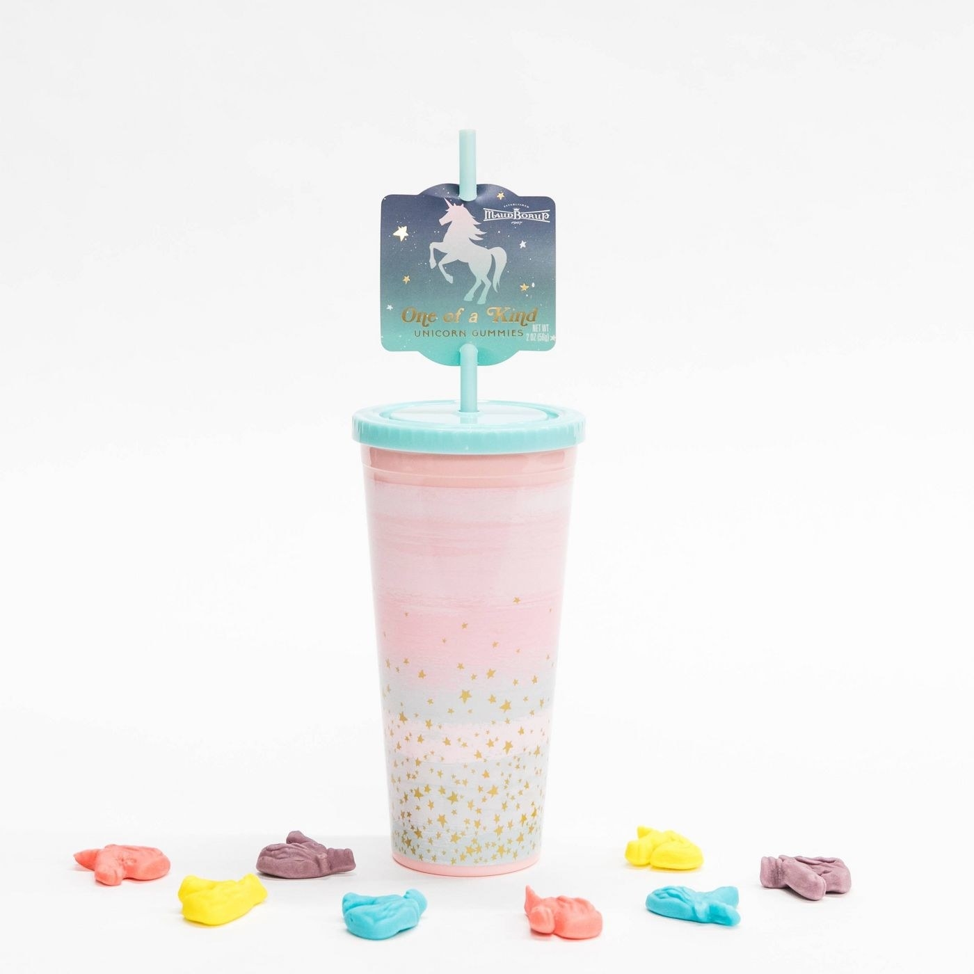 The tumbler, which has a light pink tone with light blue and white patches and gold-colored glitter flecks, as well as a light blue top and straw