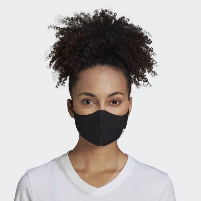 A model wearing the face mask in black