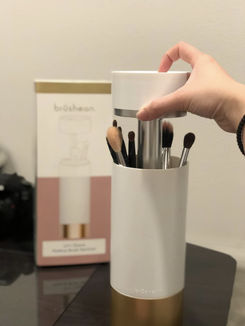 a different reviewer showing how easy it is to lift the top and put makeup brushes into the sanitizer