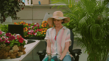 A person happily spritzing their plants while dancing during the Sunday Best music video by Surfaces
