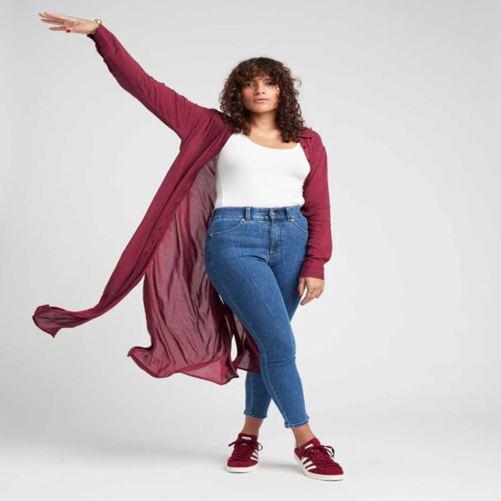 model wearing the tunic in a berry color with jeans and a tank 